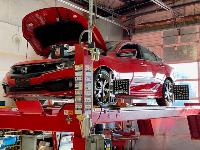 red honda sedan getting routine maintenance at Mid-Valley Auto Body